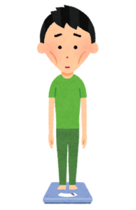 痩せた男性が体重計に乗っている